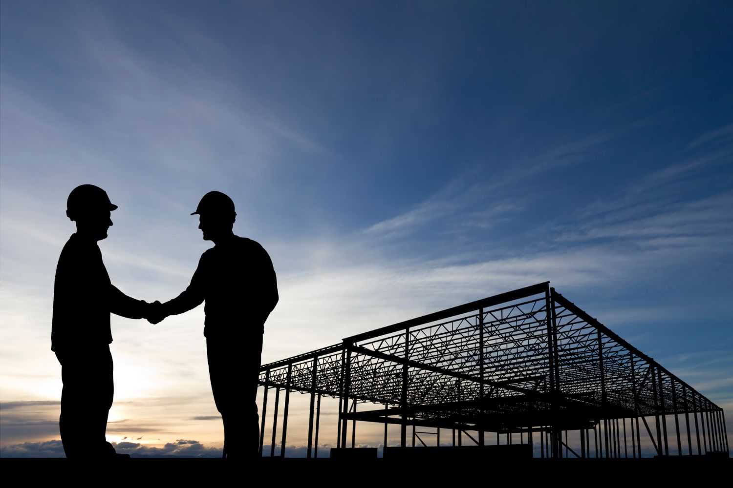 two construction workers shaking hands